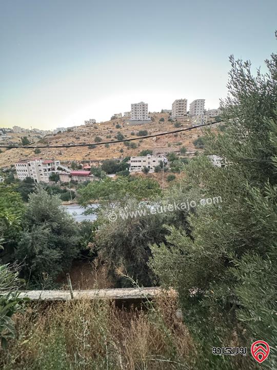 قطعة أرض تجارية مساحة 961م عليها بيت طابقين للبيع في السلط على الشارع الرئيسي مباشرة