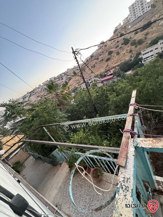 قطعة أرض تجارية مساحة 961م عليها بيت طابقين للبيع في السلط على الشارع الرئيسي مباشرة