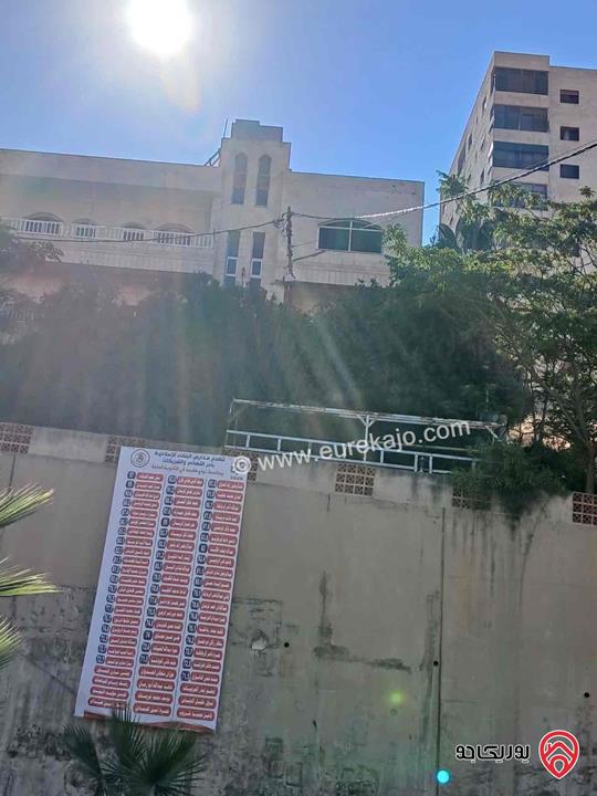 قطعة أرض تجارية مساحة 961م عليها بيت طابقين للبيع في السلط على الشارع الرئيسي مباشرة