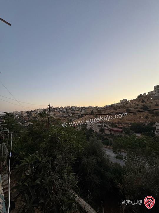 قطعة أرض تجارية مساحة 961م عليها بيت طابقين للبيع في السلط على الشارع الرئيسي مباشرة